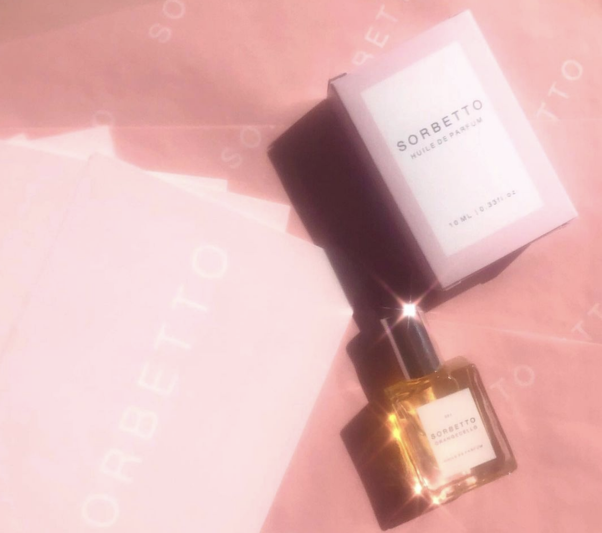 Sorbetto Fragrance and box on pink surface.
